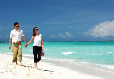tropikal beyaz kum plaj boyunca yürüyen genç sevgili Çift