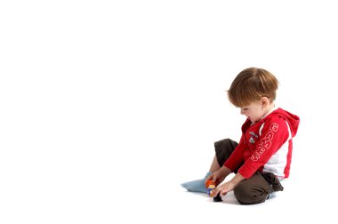 Cute 3-years old casual dressed boy playing with toys. Isolated on white background. clipart