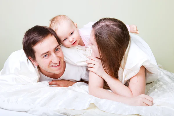 美しい若い家族の寝室で赤ちゃんの娘と — ストック写真