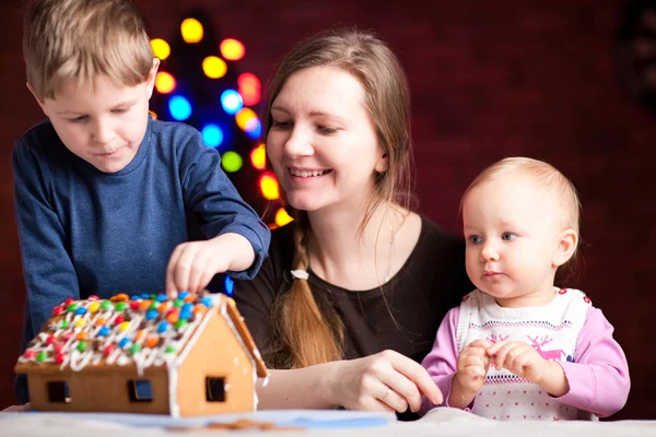 クリスマスイブに家族飾るジンジャーブレッド ハウス — ストック写真