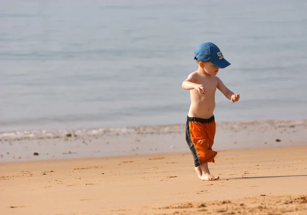 Liten pojke spelar på sandstranden — Stockfoto