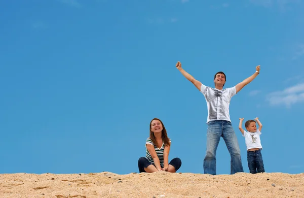 Счастливые трое на вершине песчаной дюны — стоковое фото