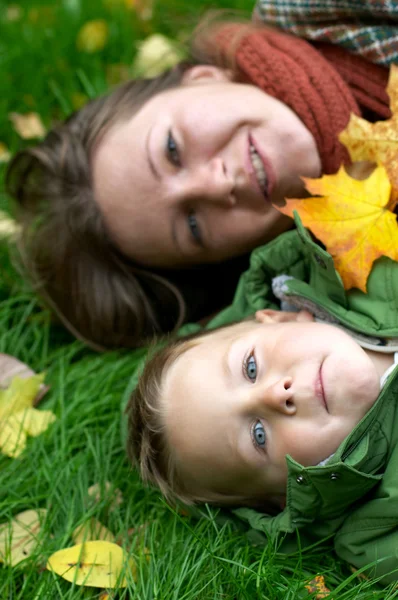 Anne Oğlu Çimenlerin Üzerinde Gülümseyen Düşen Yapraklarla Kaplı — Stok fotoğraf