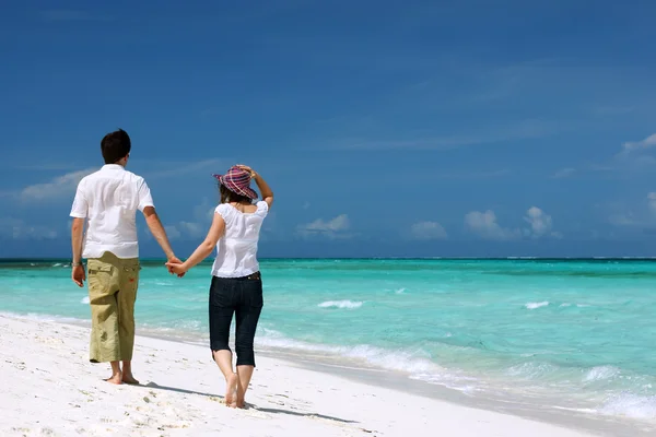 熱帯の白い砂のビーチに沿って歩いて若い愛するカップル — ストック写真
