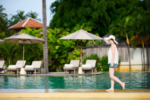 美丽的少女走沿着游泳池在热带度假村 — 图库照片