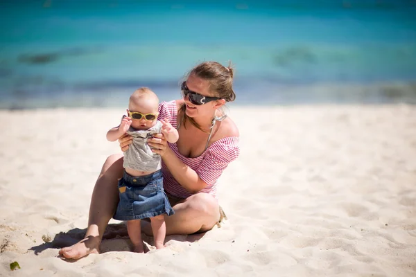 年轻的母亲和宝贝女儿在热带的白色沙滩上的太阳镜 — 图库照片