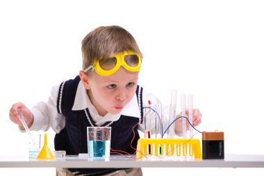 Crazy scientist. Young boy performing experiments with battery and small lamp.