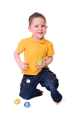 Cute 3-years old boy playing with Easter eggs. Isolated on white. clipart