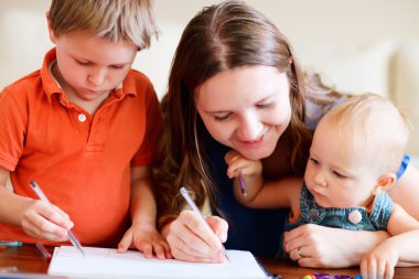 Young mother and her two kids drawing together. Can be used also in kindergarten/daycare context clipart