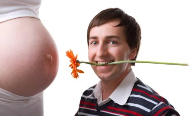 33-weeks pregnant belly and happy father-to-be holding gerber flower. Isolated on white background clipart