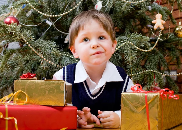 Χαριτωμένο Μικρό Αγόρι Παρουσιάζει Κοντά Χριστουγεννιάτικο Δέντρο — Φωτογραφία Αρχείου
