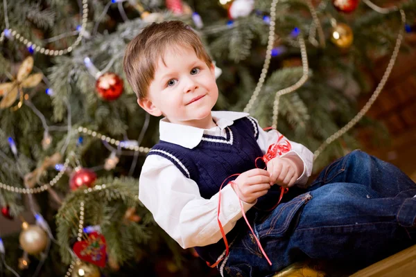 Χαριτωμένο Μικρό Αγόρι Κοντά Χριστουγεννιάτικο Δέντρο Αποσυμπίεση Παρουσιάζει — Φωτογραφία Αρχείου