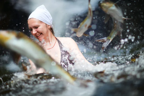 多くの魚と滝で泳いでいる若い女性 — ストック写真