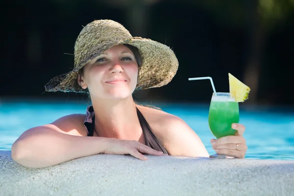 熱帯飲み物のガラス付きのスイミング プールでリラックスした女の子 — ストック写真