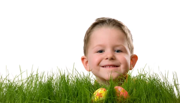 イースターエッグハント 新鮮な緑の草の中に隠されたイースターエッグを探しているかわいい男の子 白地に隔離された — ストック写真