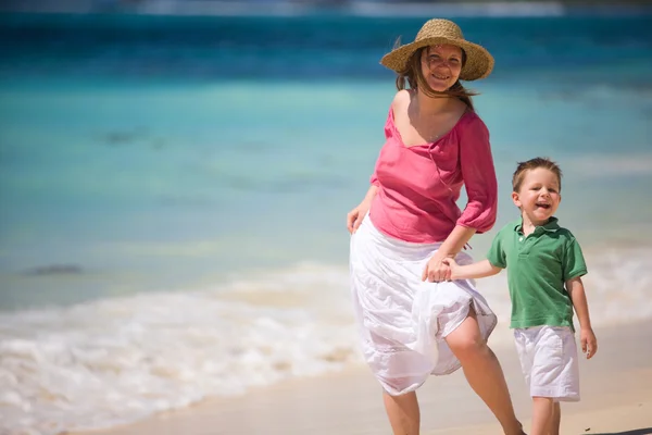 幸福的母亲和儿子在热带的白色沙滩上 — 图库照片