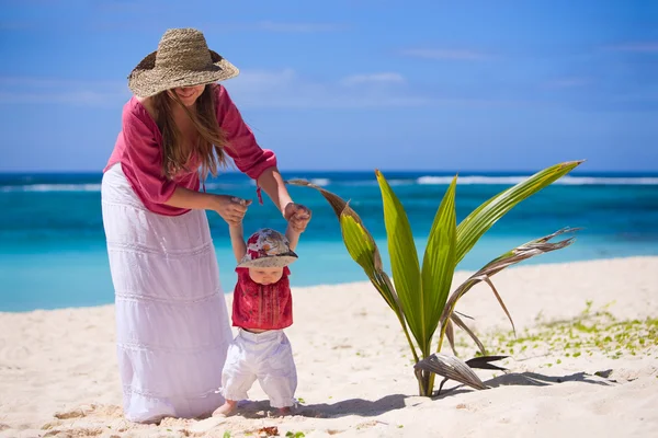 年轻的母亲和宝贝女儿在热带的白色沙滩上 — 图库照片