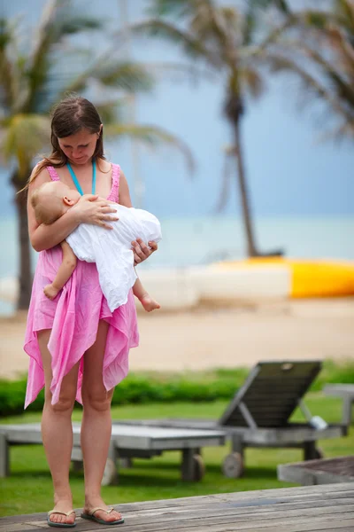 年轻的母亲和睡在沙滩上的女婴 — 图库照片