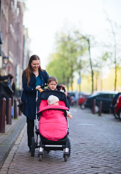 屋外を歩く 人の子供を持つ母 — ストック写真