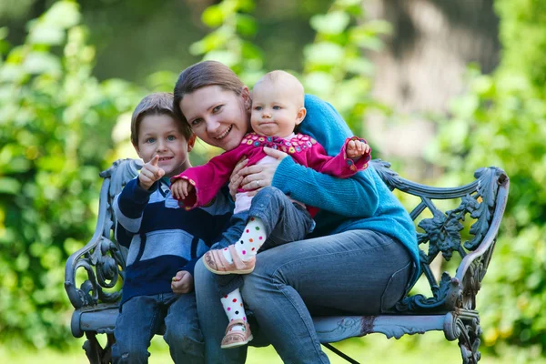 幸福的母亲和两个孩子户外活动在阳光明媚的秋日花时间 — 图库照片