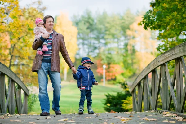 年轻的父亲与两个孩子享受美丽秋季的一天 — 图库照片