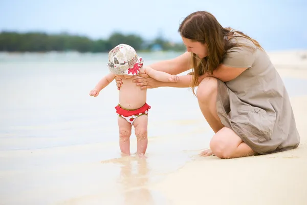 在热带的白色沙滩上的宝贝女儿的年轻家庭 — 图库照片