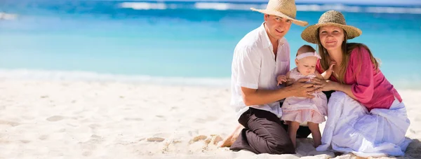 家庭度假 年轻的家庭的热带的白色沙滩上有三个 — 图库照片