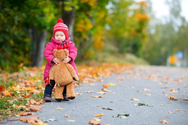 宝贝可爱女孩与玩具熊在美丽的秋天晴天户外散步 — 图库照片