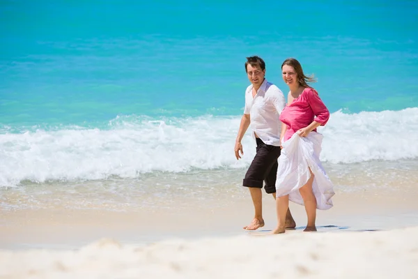 ロマンチックなカップルは熱帯の白砂のビーチに沿って歩く — ストック写真