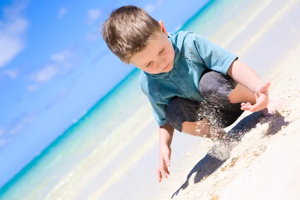 小男孩玩热带的白色沙滩 — 图库照片