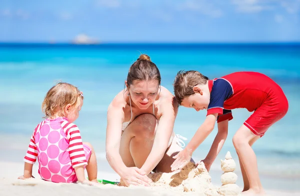 Matka z dziećmi na wakacje na plaży — Zdjęcie stockowe