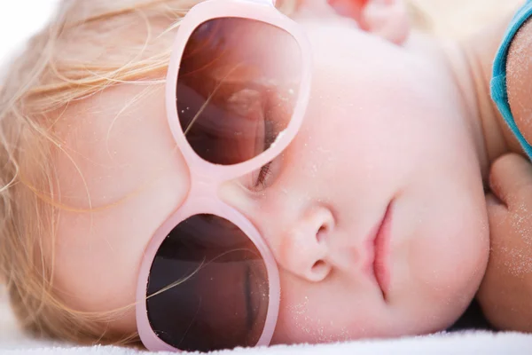 Kleines Mädchen schläft am Strand — Stockfoto