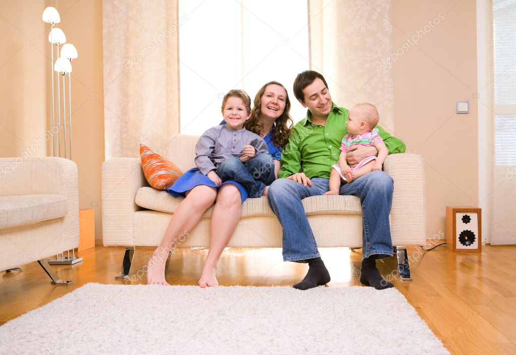 Happy young family of four enjoying time at their home