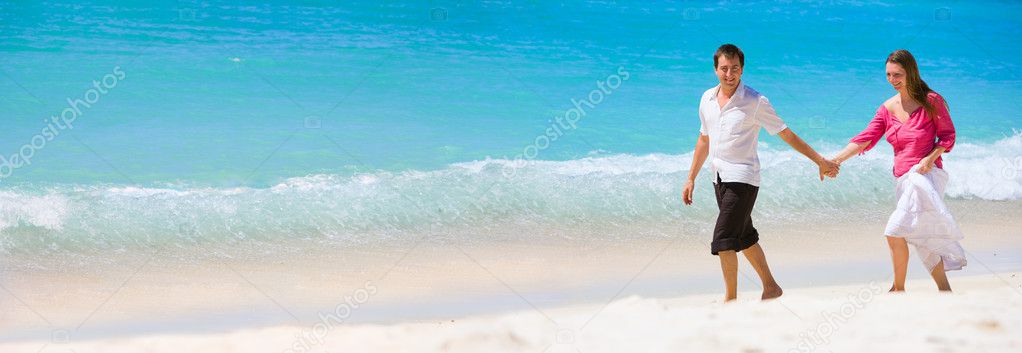 Panorama of romantic couple on white sand beach