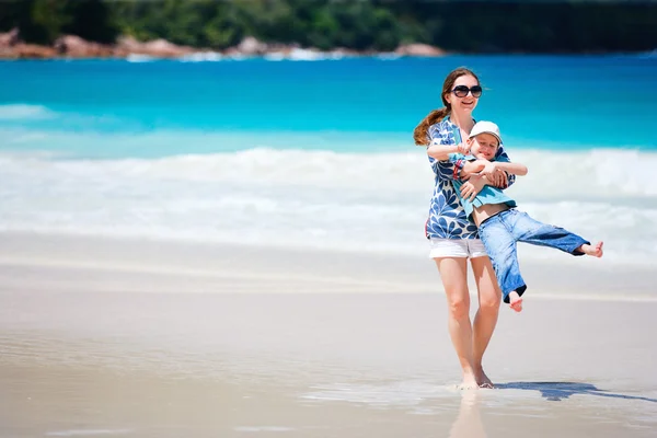 幸福的母亲和儿子在热带海滩 — 图库照片