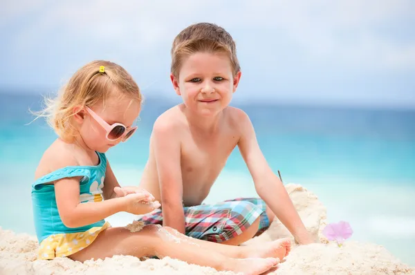 Двое детей играют вместе на пляже — стоковое фото