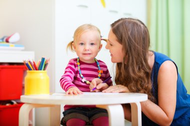 Mother and daughter drawing together clipart