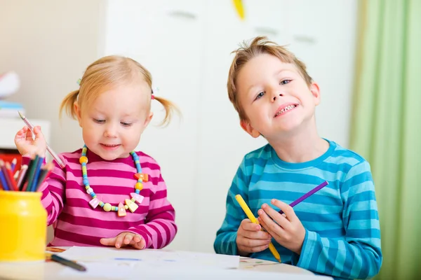 Twee kinderen tekenen met kleuren potloden — Stockfoto