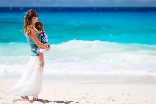 年轻的母亲抱着小女儿站在热带海滩和海洋期待 — 图库照片