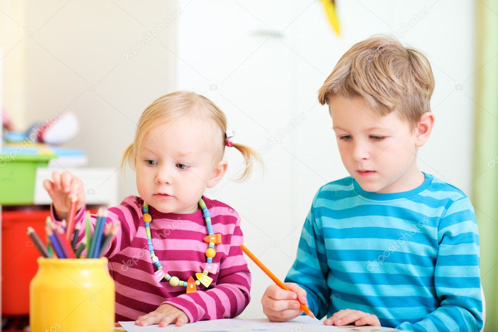 Brother and sister drawing together with coloring pencils
