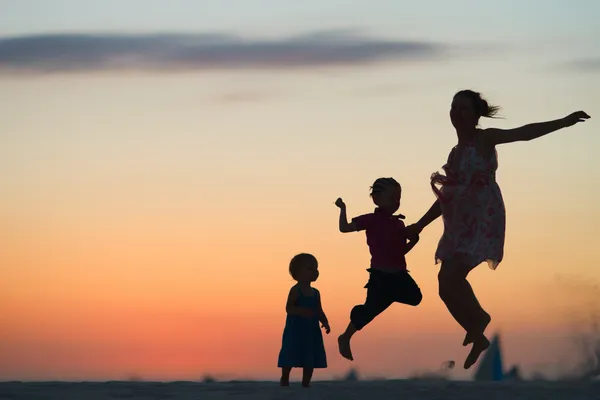 Divertimento in famiglia sulla spiaggia al tramonto — Foto Stock
