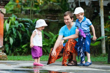 Father and two kids at Bali temple clipart