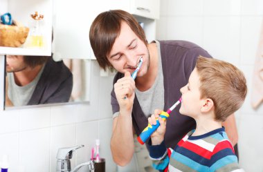 Father and son brushing teeth clipart