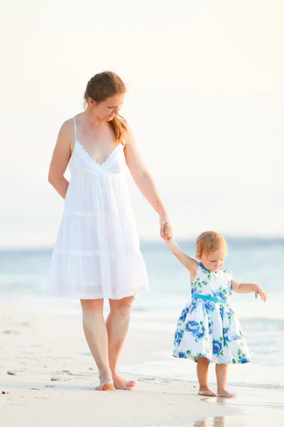 Mãe e filha na praia tropical ao pôr do sol — Fotografia de Stock