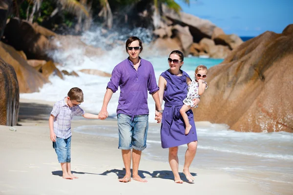 Jovem família andando ao longo da praia — Fotografia de Stock