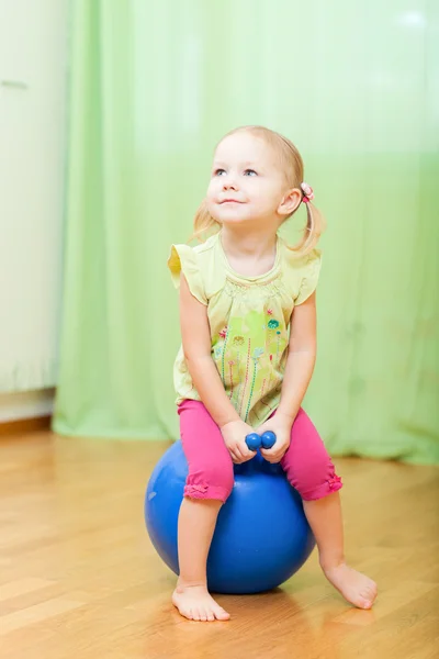 Маленькая девочка, прыгающая на мяче — стоковое фото