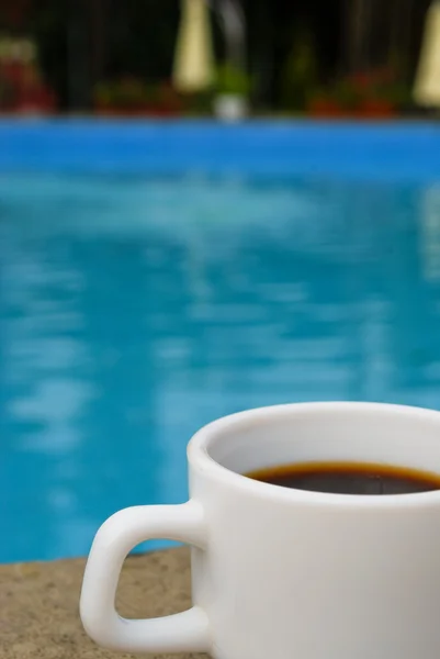 White cup of coffee at swimming-pool — Stock Photo, Image
