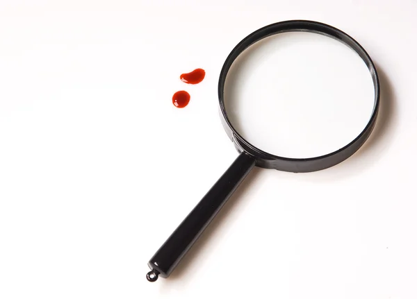 Magnifying glass and blood drops over white background — Stock Photo, Image