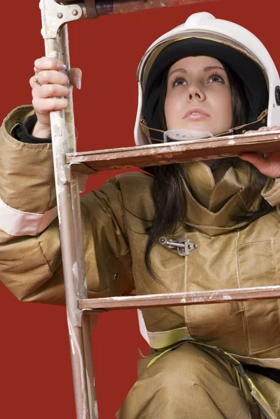 Девушка в форме пожарного наверху — стоковое фото