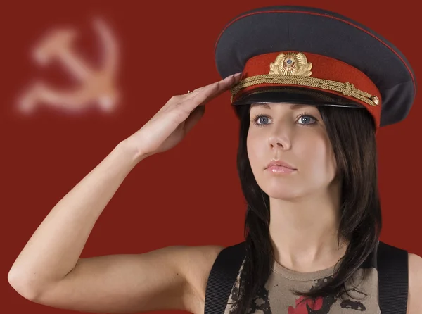 Das Mädchen mit der Milizmütze auf dem Hintergrund sowjetischer Symbole — Stockfoto